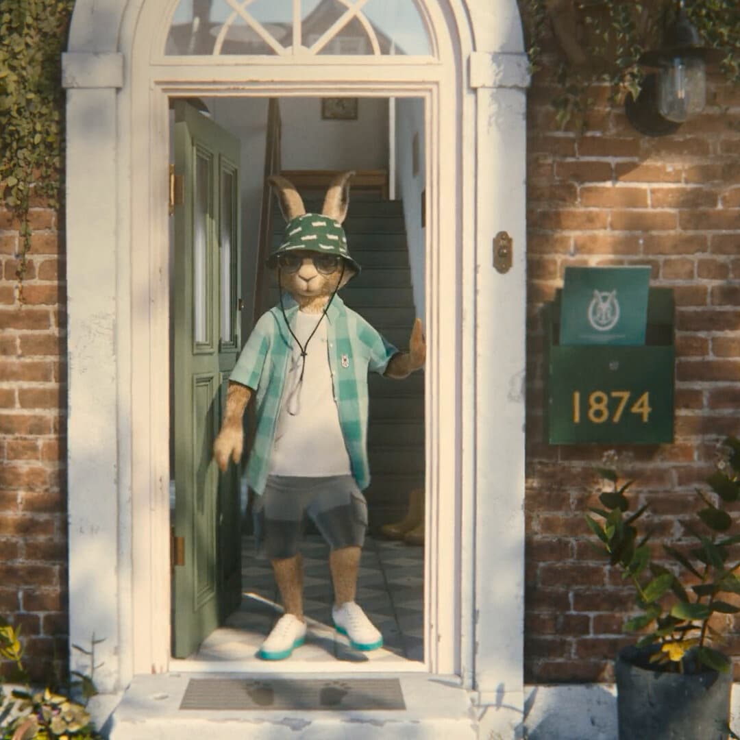 Vaillant Hase steht mit Sonnenhut auf dem Kopf in einer Haustür.