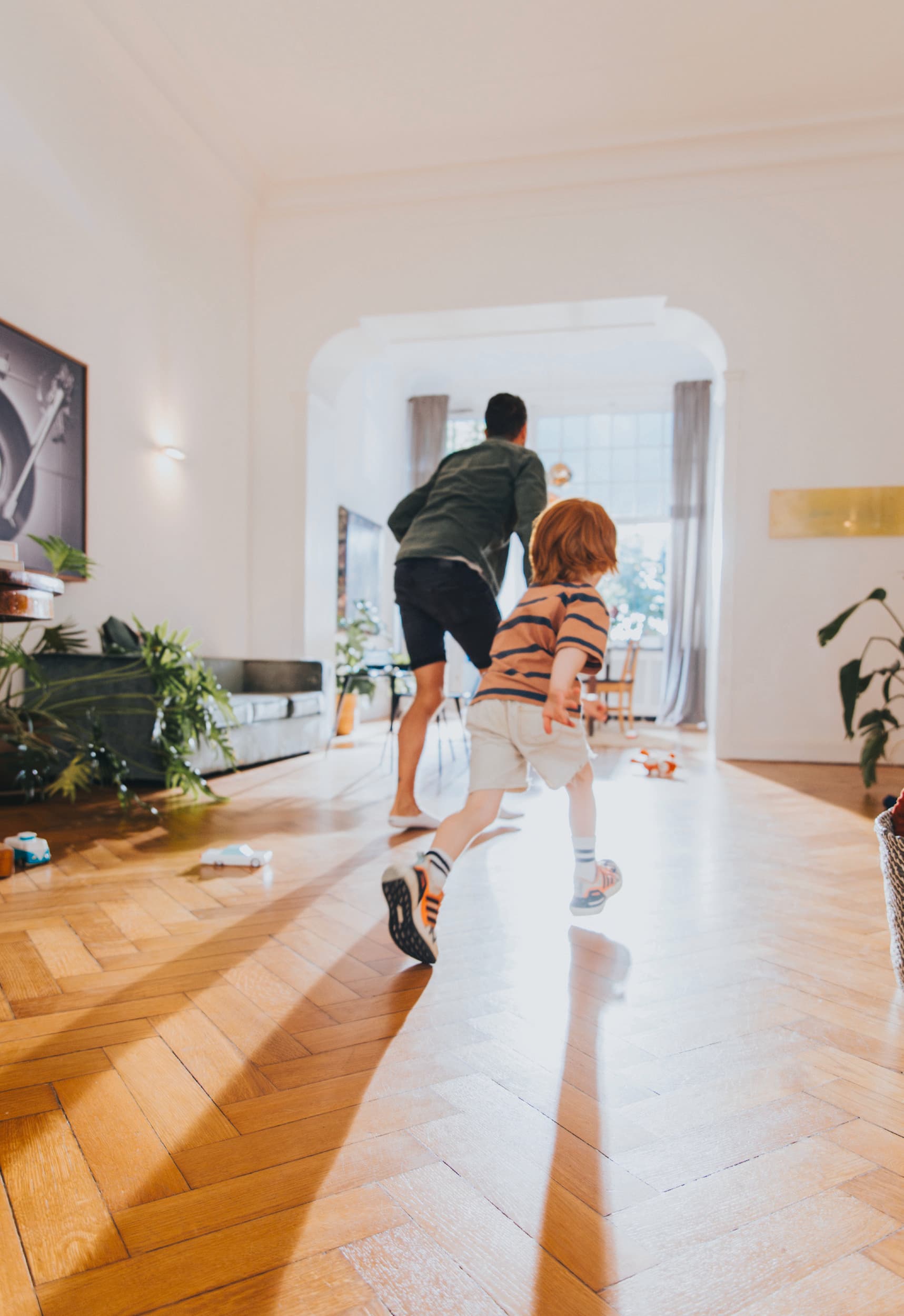 Mann spielt mit seinem Kind im Wohnzimmer