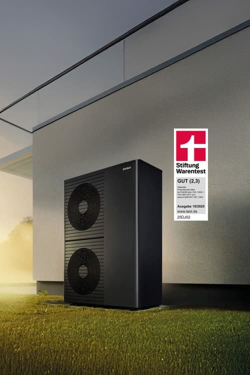 Eine Vaillant Wärmepumpe in steht vor einer Hauswand und wird von Abendsonne beschienen. Rechts daneben wird ein Siegel der Stiftung Warentest mit der Note gut eingeblendet.
