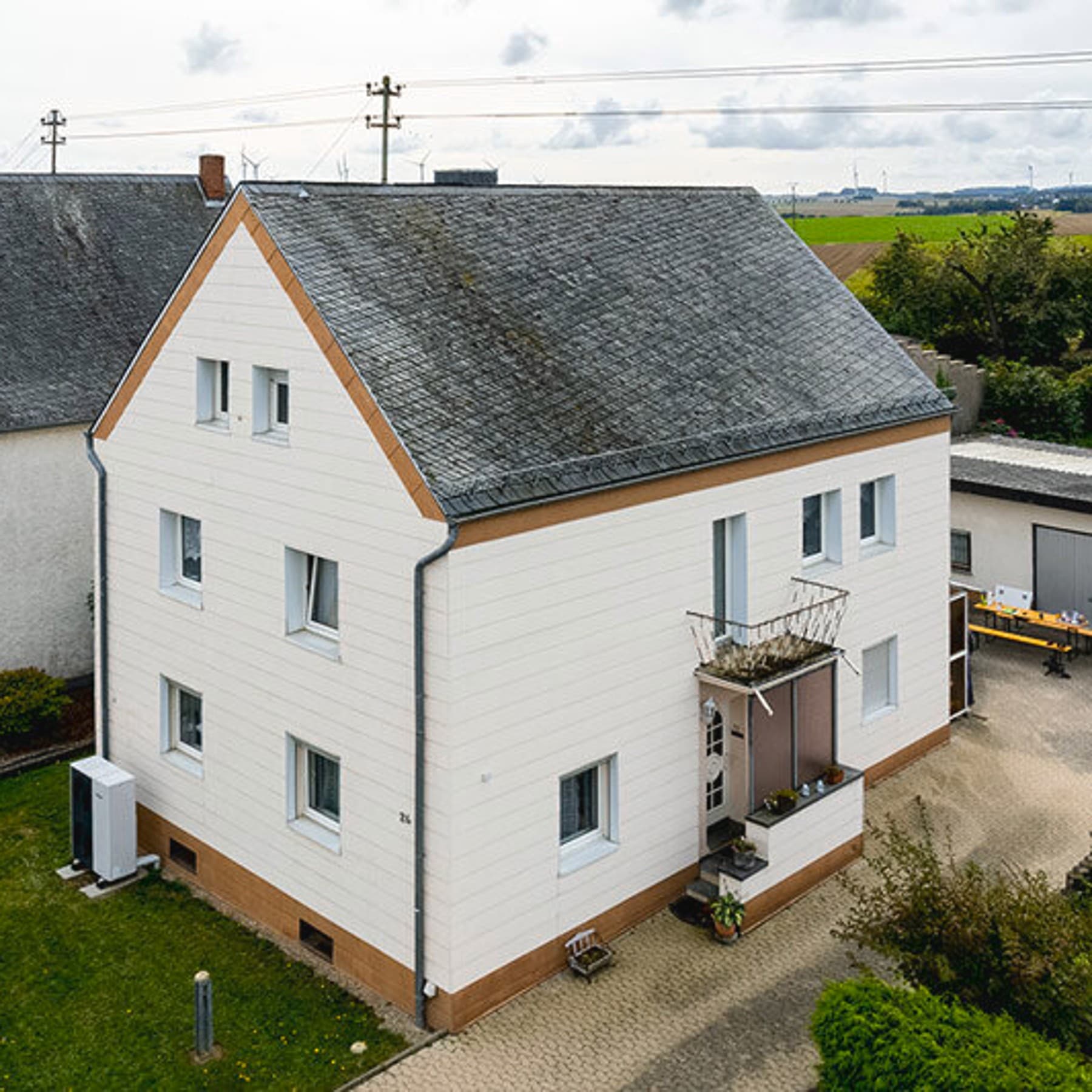 Luftaufnahme vom Einfamilienhaus mit Wärmepumpe im Vorgarten