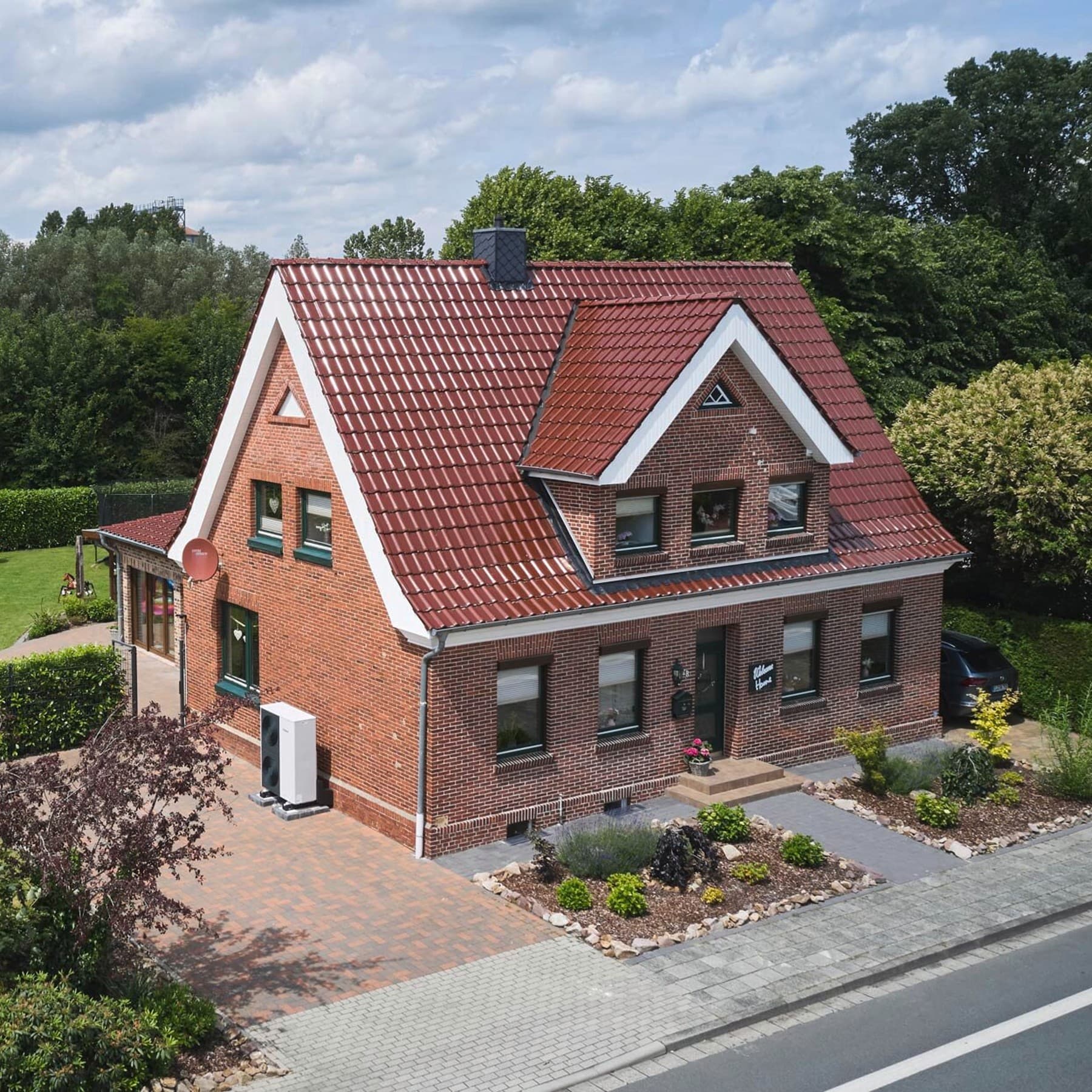Einfamilienhaus mit Wärmepumpe vor dem Haus