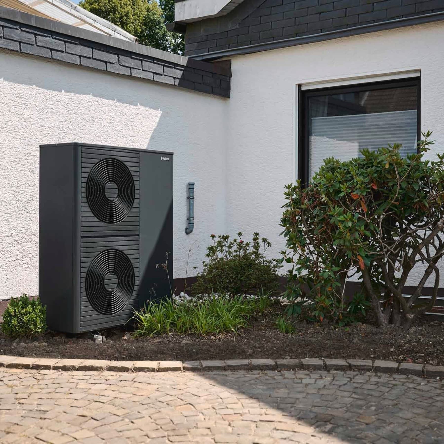 Eine Vaillant Wärmepumpe vor einem Altlbau