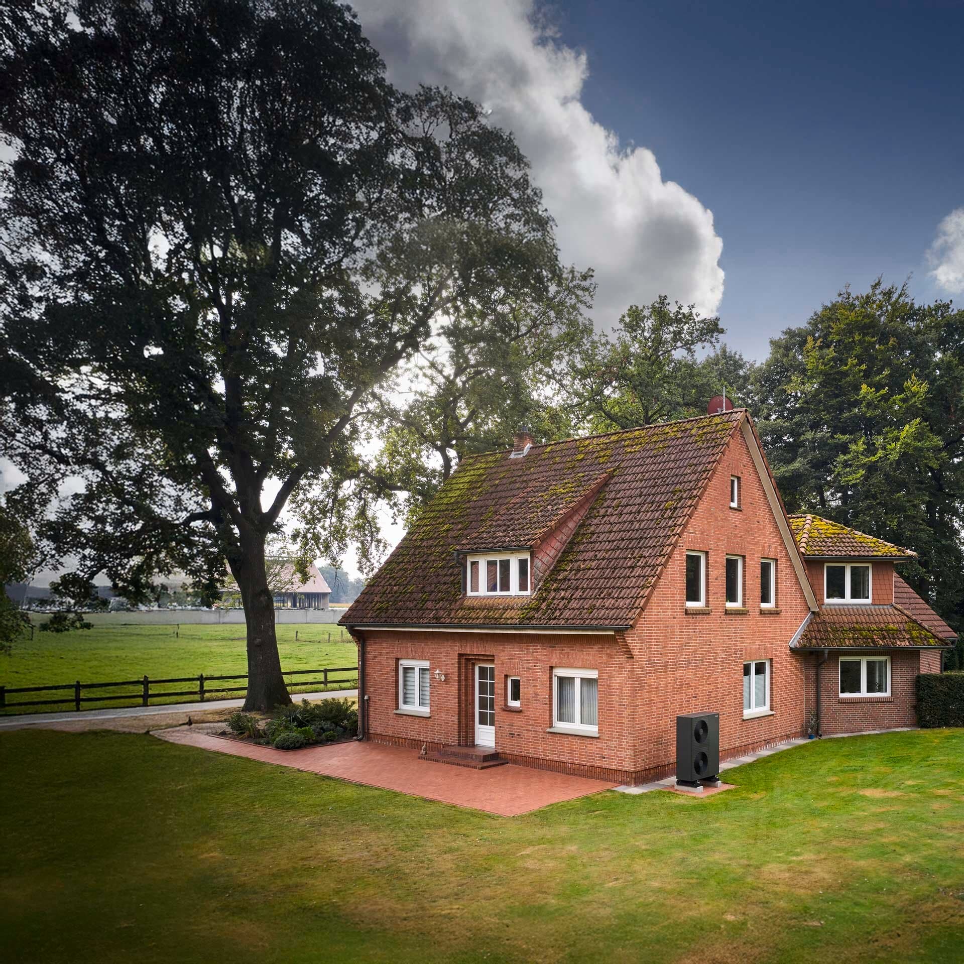 Außenansicht des Gebäudes mit schwarzgrauer Vaillant Wärmepumpe vor der Hauswand