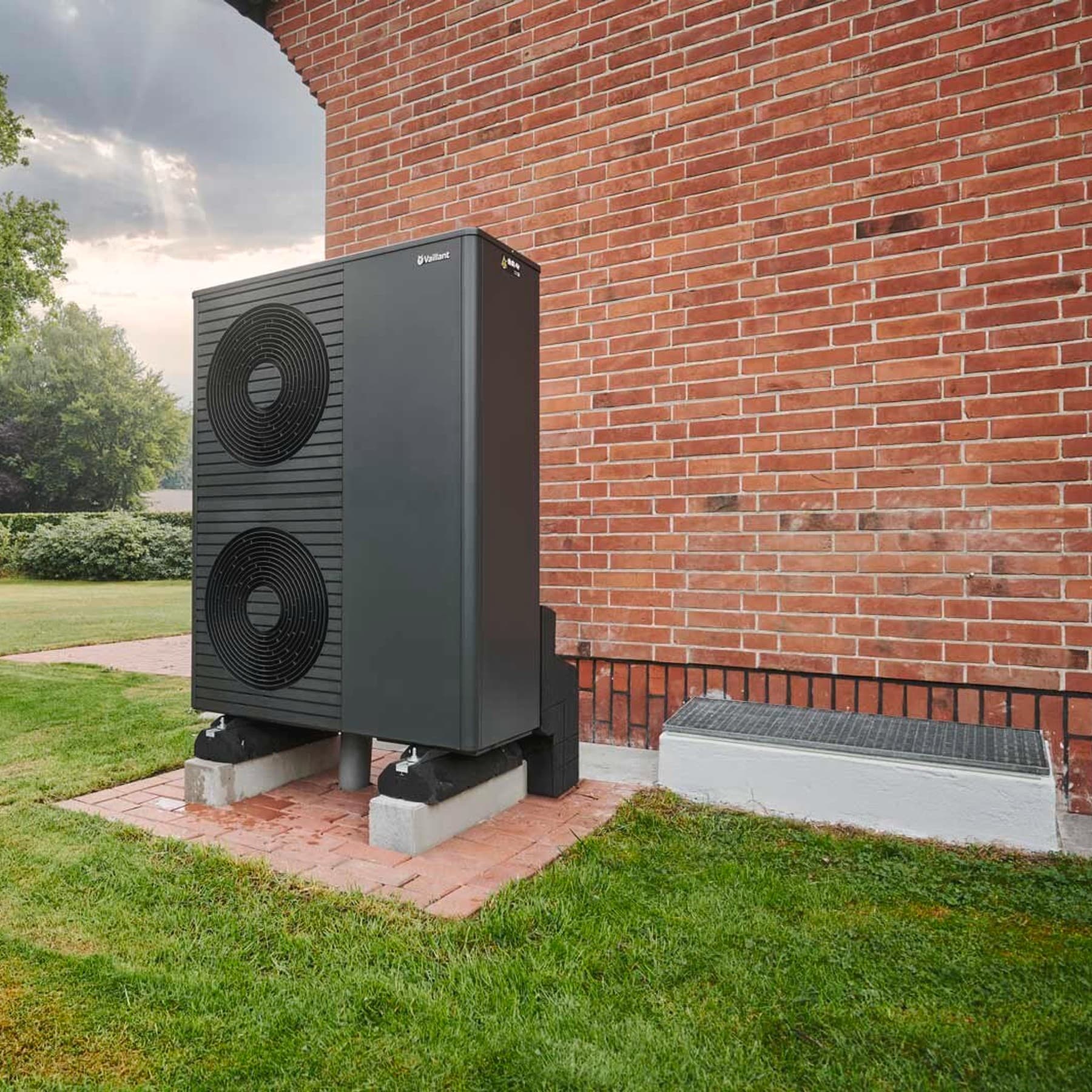 Vaillant Wärmepumpen-Außeneinheit neben einem Kellerschacht