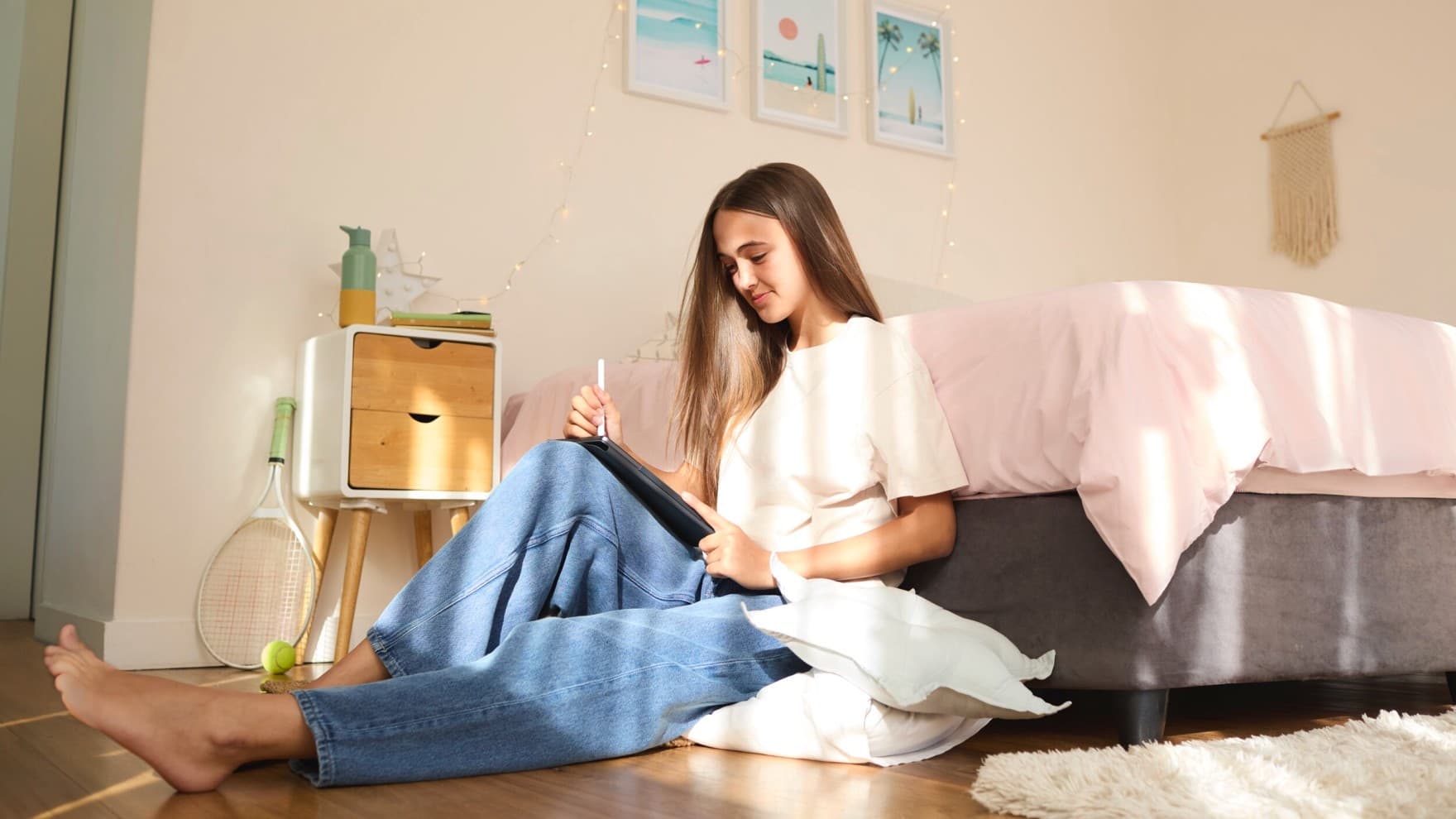 Ein Mädchen hält die Fernbedienung der Vaillant Klimaanlage climaVAIR plus in der Hand. Im Hintergrund hängen Bilder und eine Klimaanlage an der Wand.
