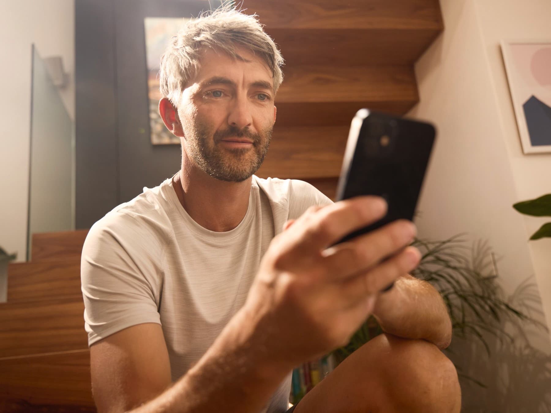 Bild von einem Mann, der sein Handy in der Hand hält