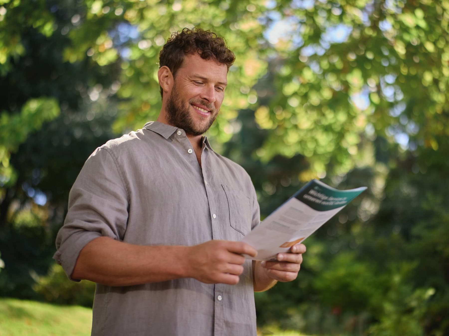 Ein Mann informiert sich mit einer Broschüre über Förderprogramme