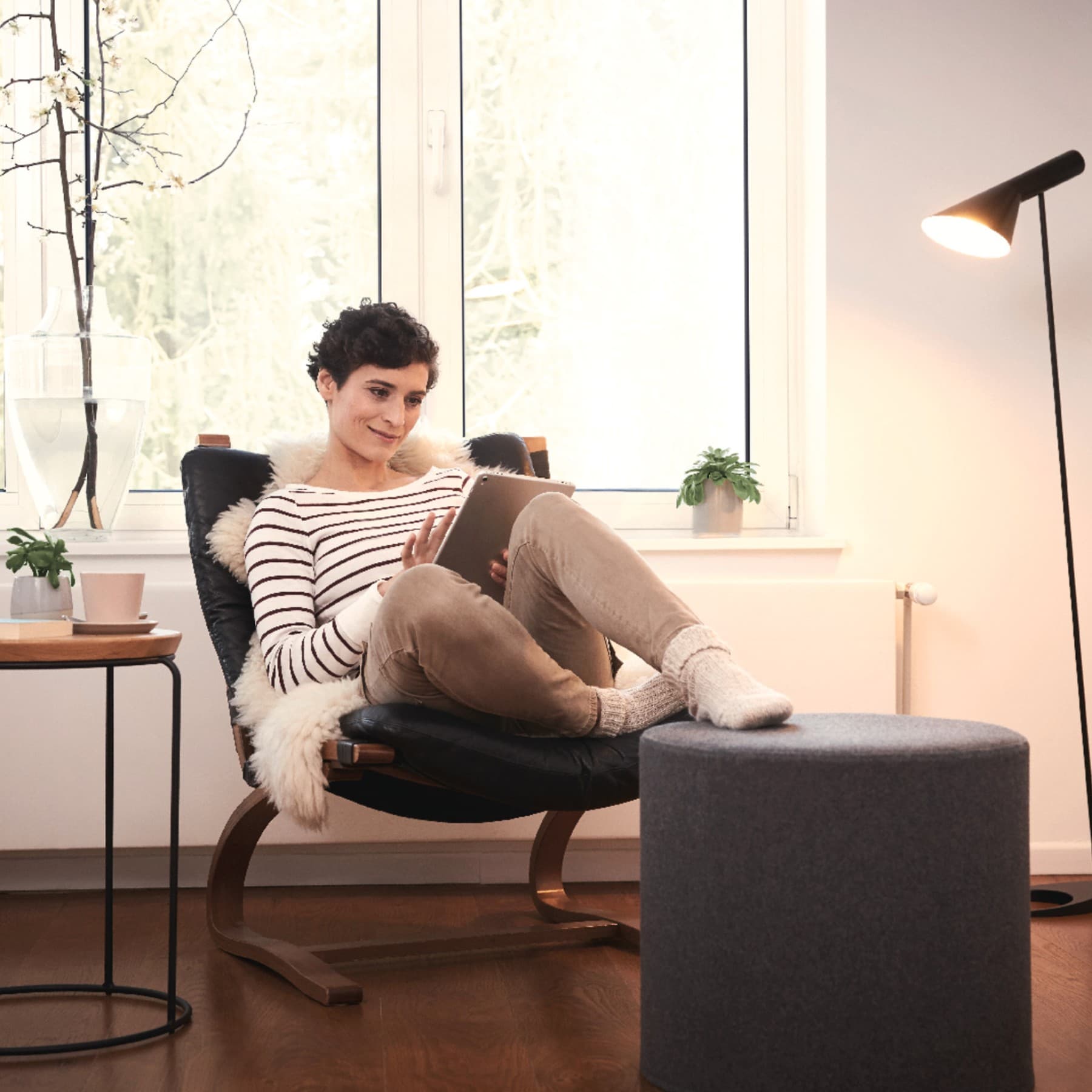 Frau auf einem Sessel mit einem Tablet in der Hand