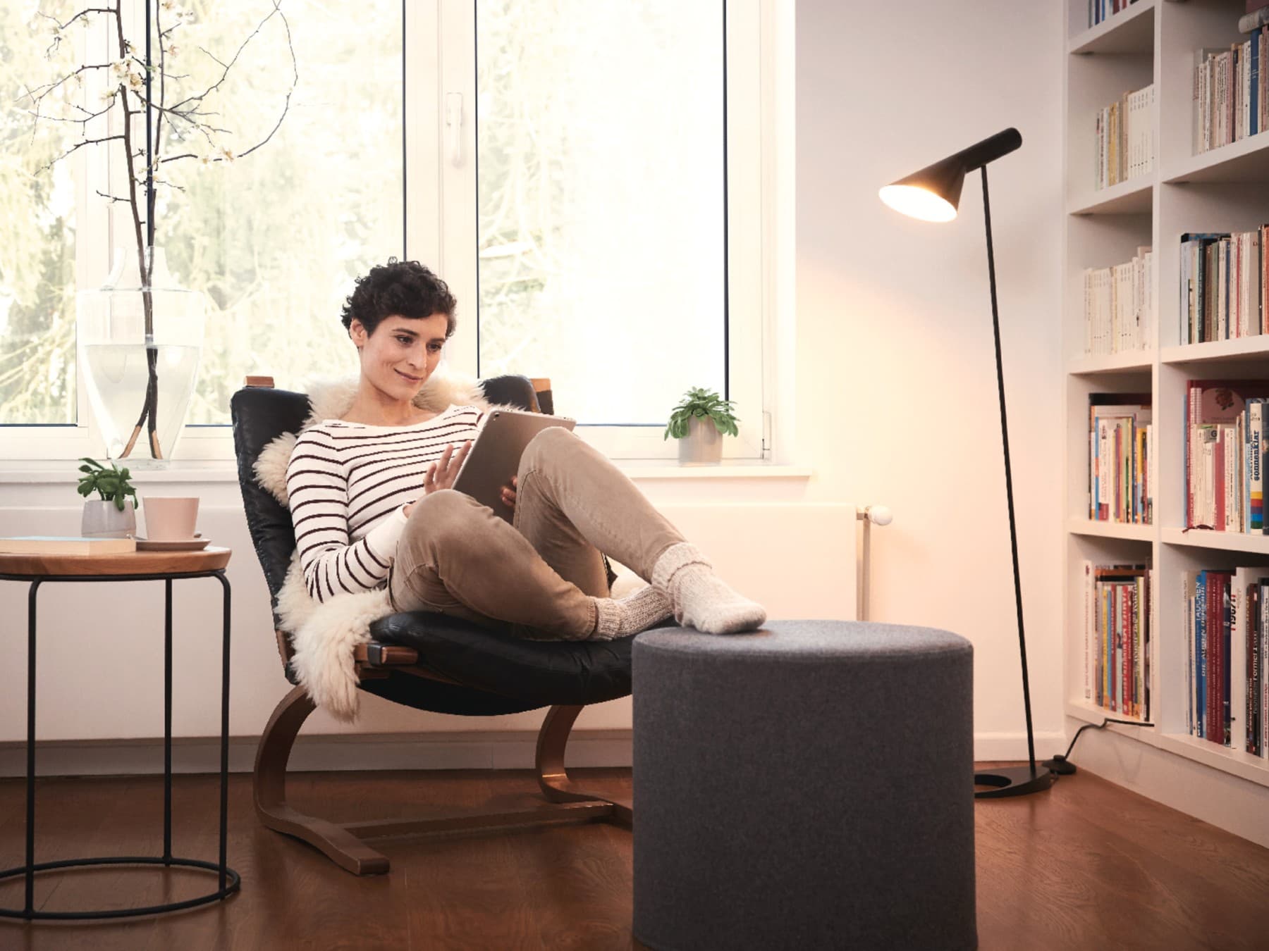 Frau auf einem Sessel mit einem Tablet in der Hand
