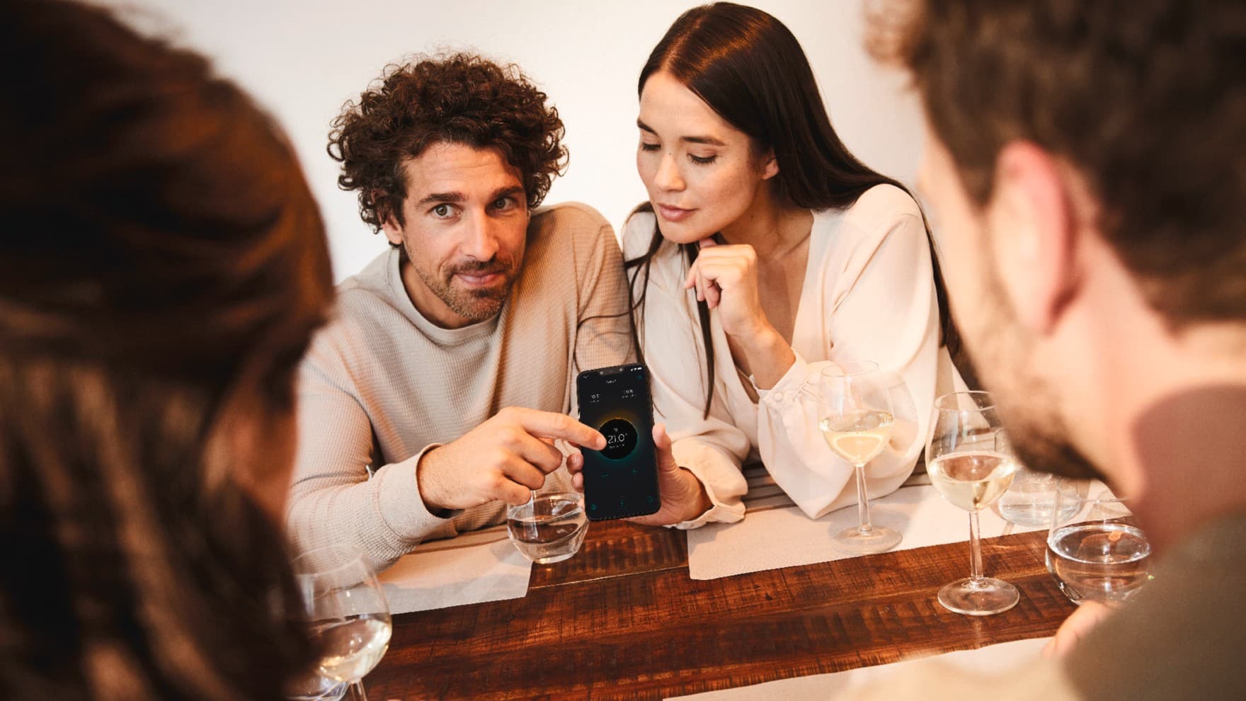 Zwei Personen, die ein Smartphone mit der geöffneten myVAILLANT App in der Hand halten