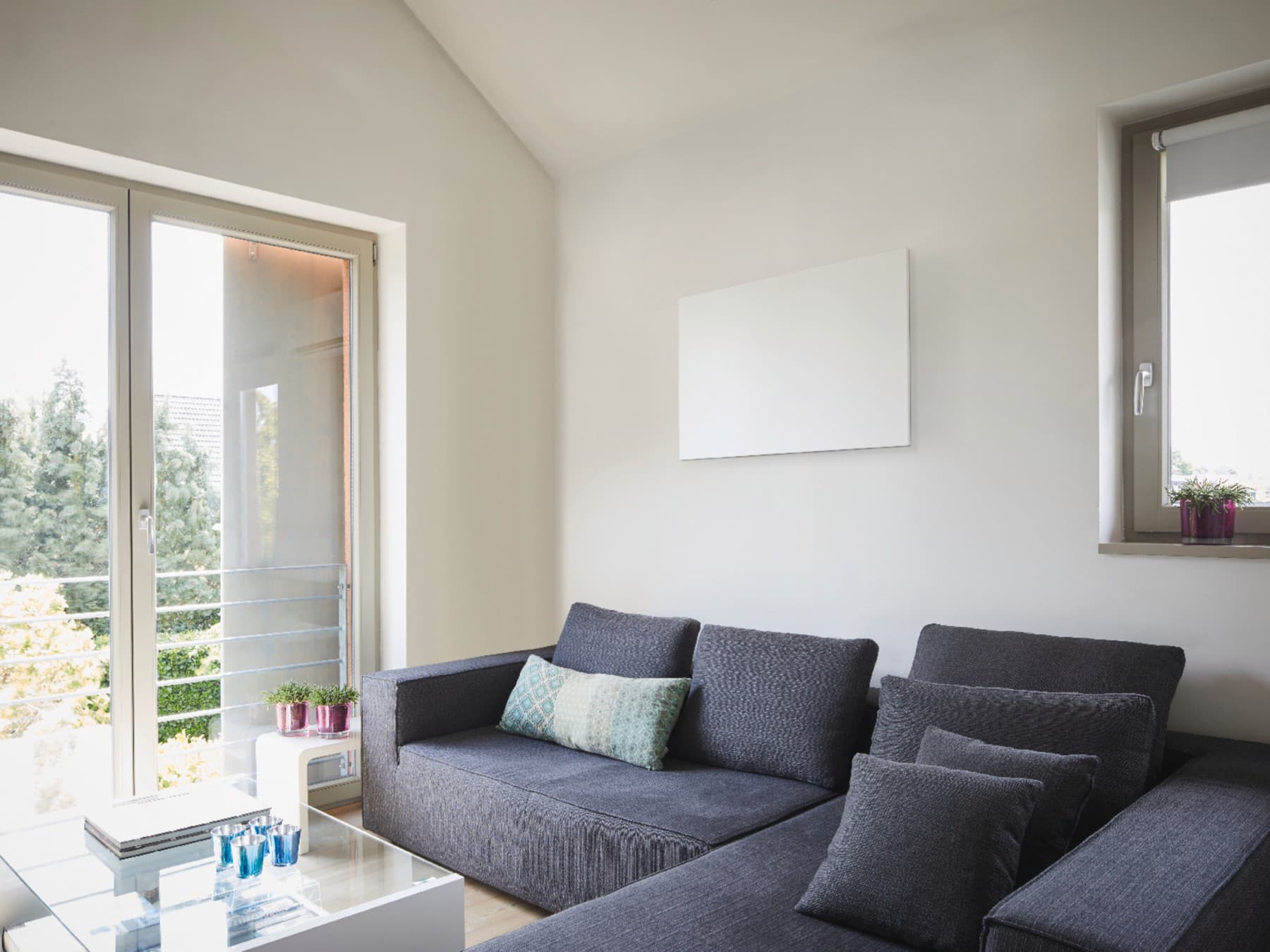 Eine Vaillant Infrarotheizkörper hängt über dem Sofa an der Wand.