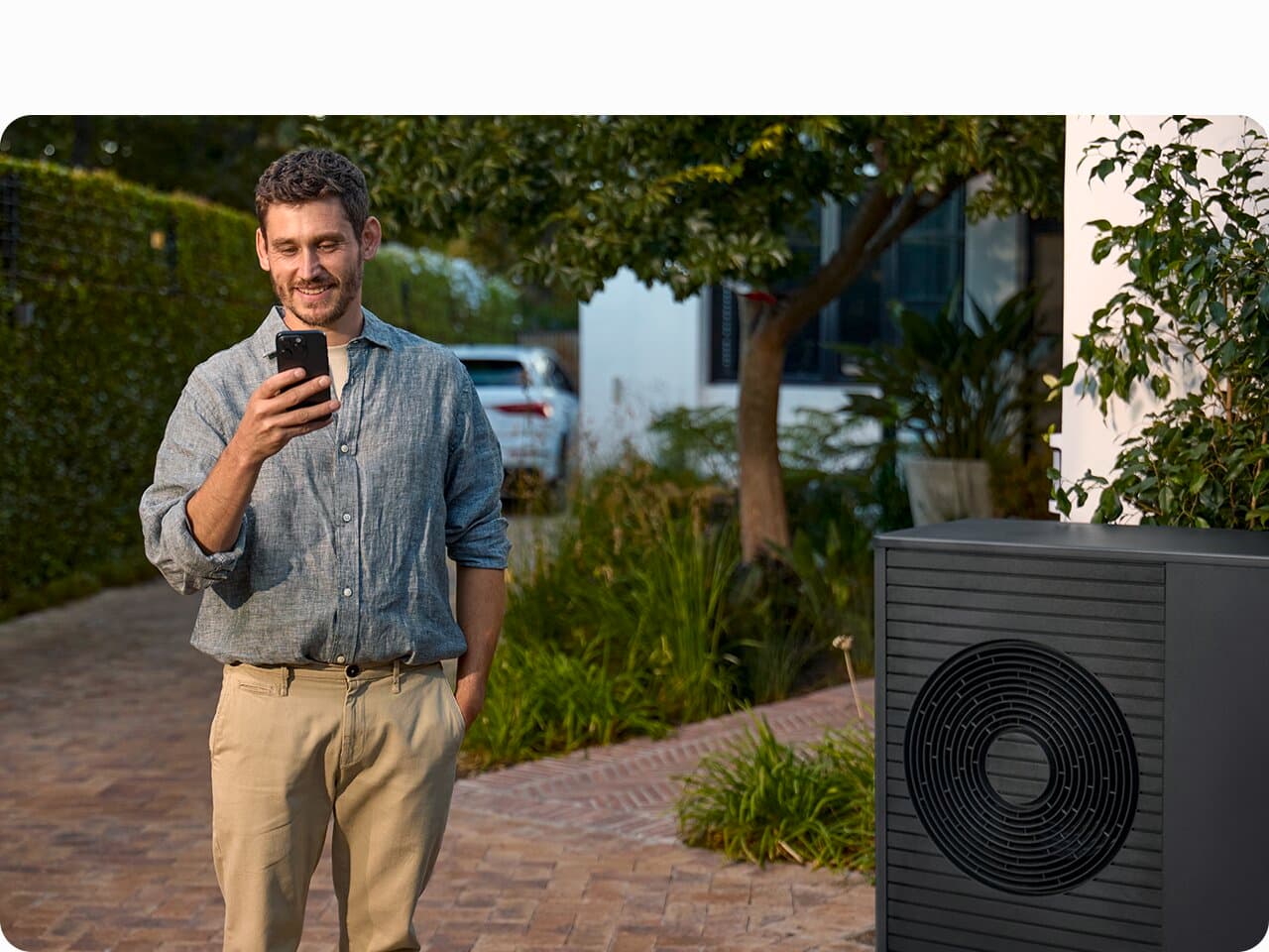 Ein Mann stellt seine Wärmepumpe bequem per Handy ein für einen kostenoptimalen Betrieb über EnergiePLUS.