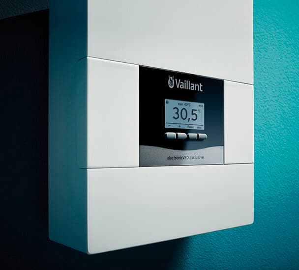 Ein Vaillant electronicVED exclusive hängt an einer grünen Wand, es ist eine Nahaufnahme des digitalen Displays zu sehen.