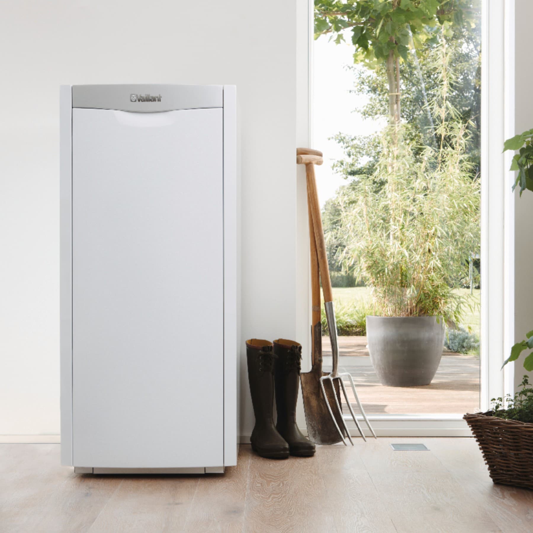 Vaillant Öl-Brennwertkessel icoVIT exclusiv steht im hellen Kellerraum neben der geöffneten Kellertüre mit Blick in den grünen Garten.