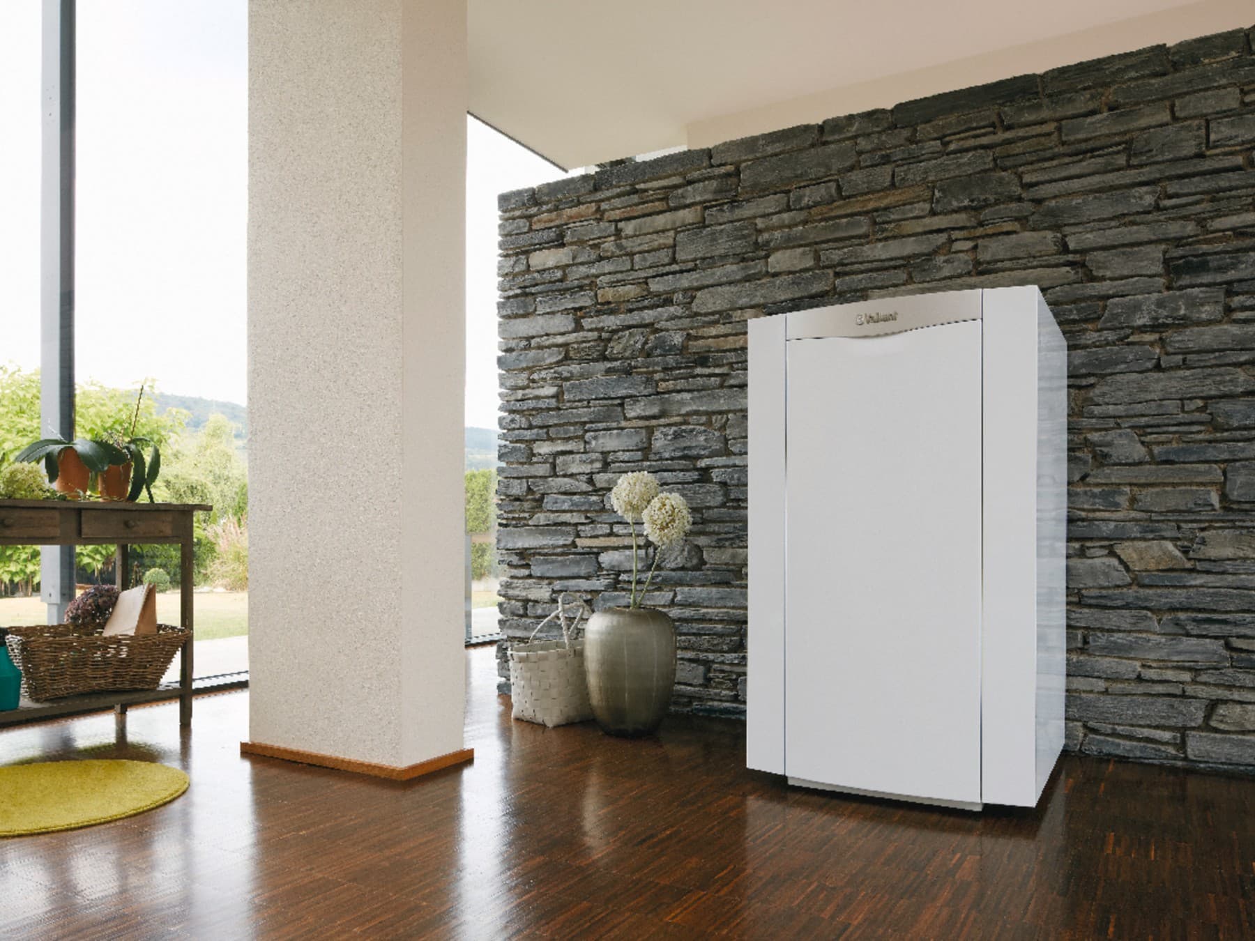 Öl-Brennwertkessel von Vaillant steht vor einer Steinwand im lichtdurchflutetem Souterrain-Kellerraum mit großer Fensterfront