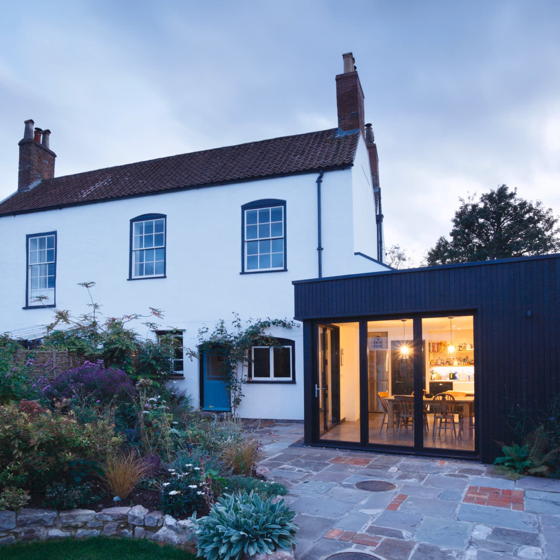 Außenansicht eines Wohngebäudes mit Anbau aus dem Garten