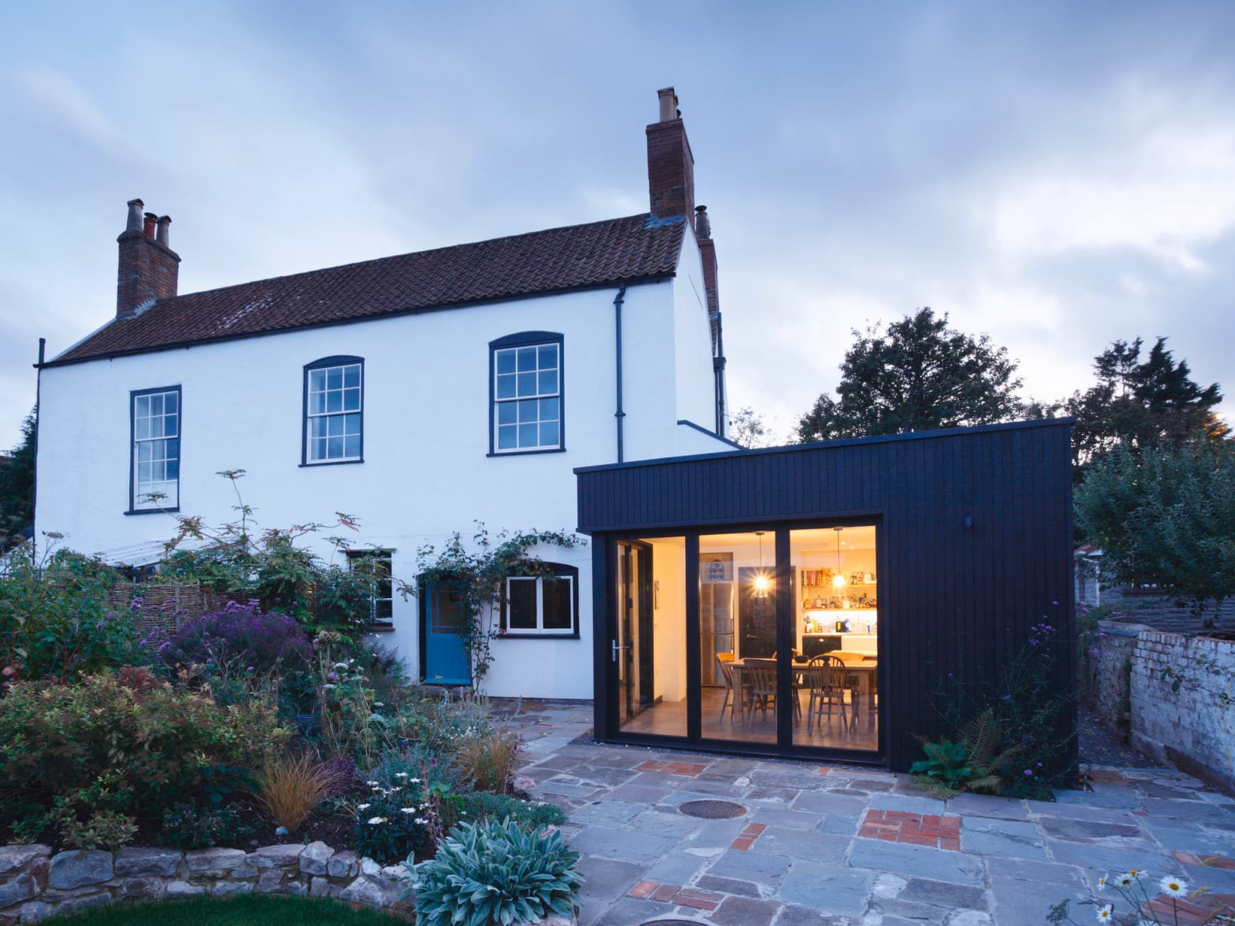 Außenansicht eines Wohngebäudes mit Anbau aus dem Garten