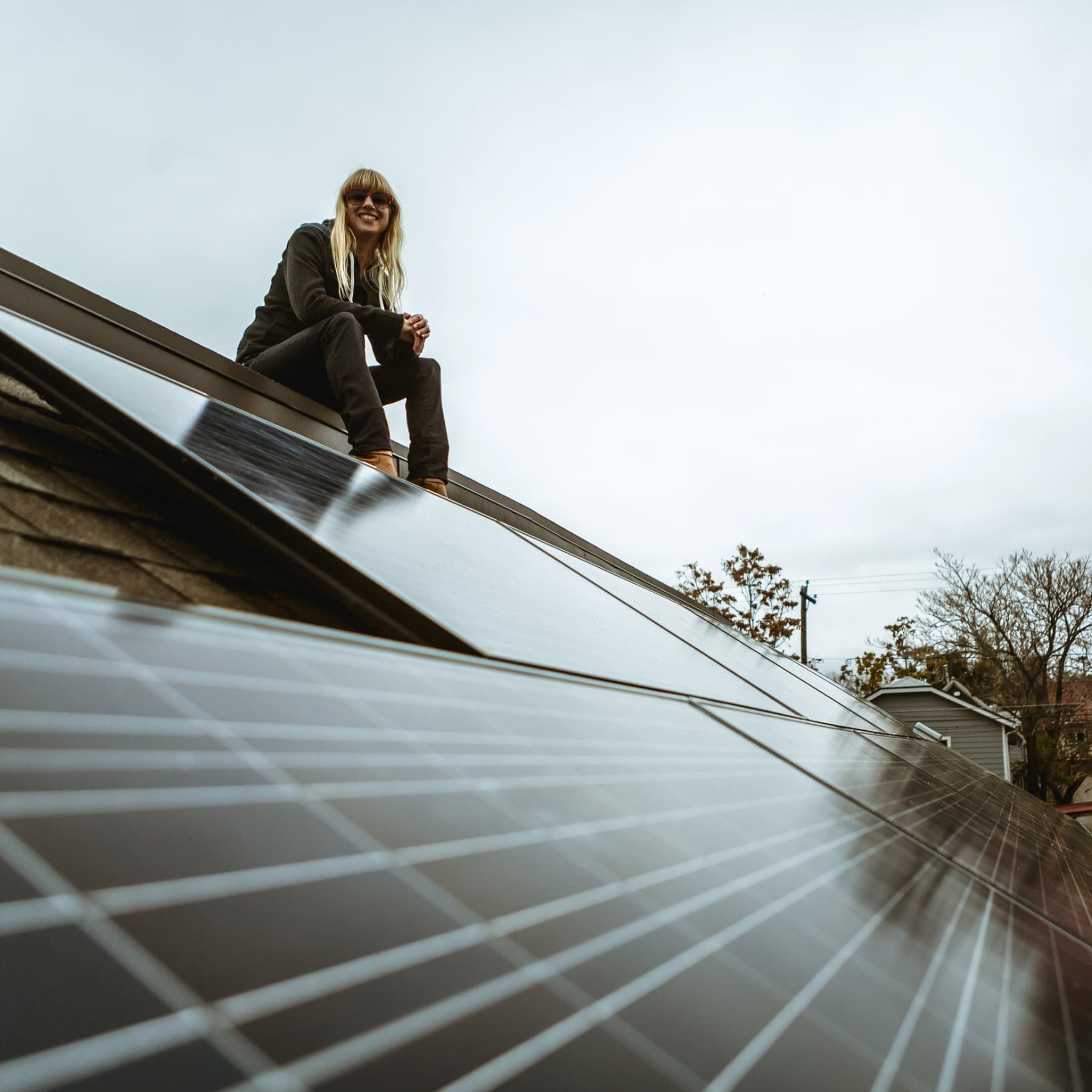 Fachhandwerkerin auf dem Dach mit Photovoltaikanlage