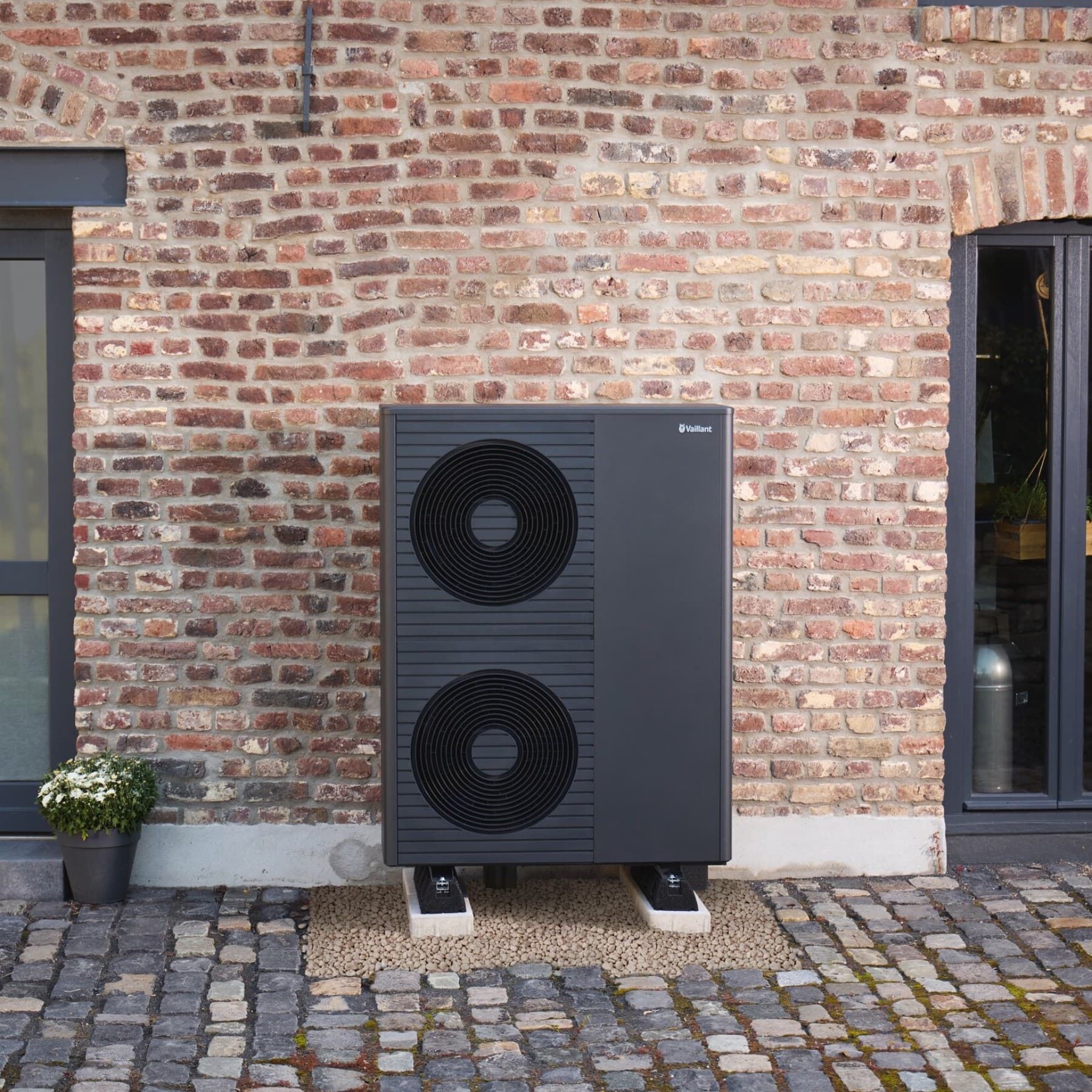 Eine neue Vaillant Wärmepumpe vor einem alten Haus.