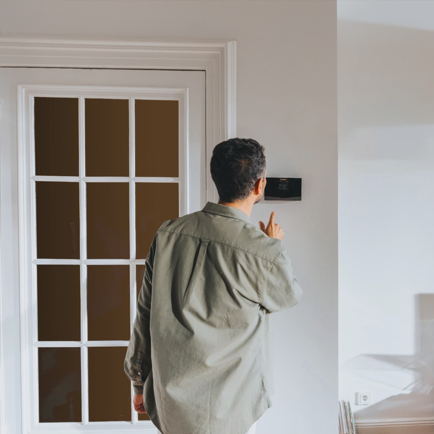 Mann steht vor einem Regler und schaut drauf.