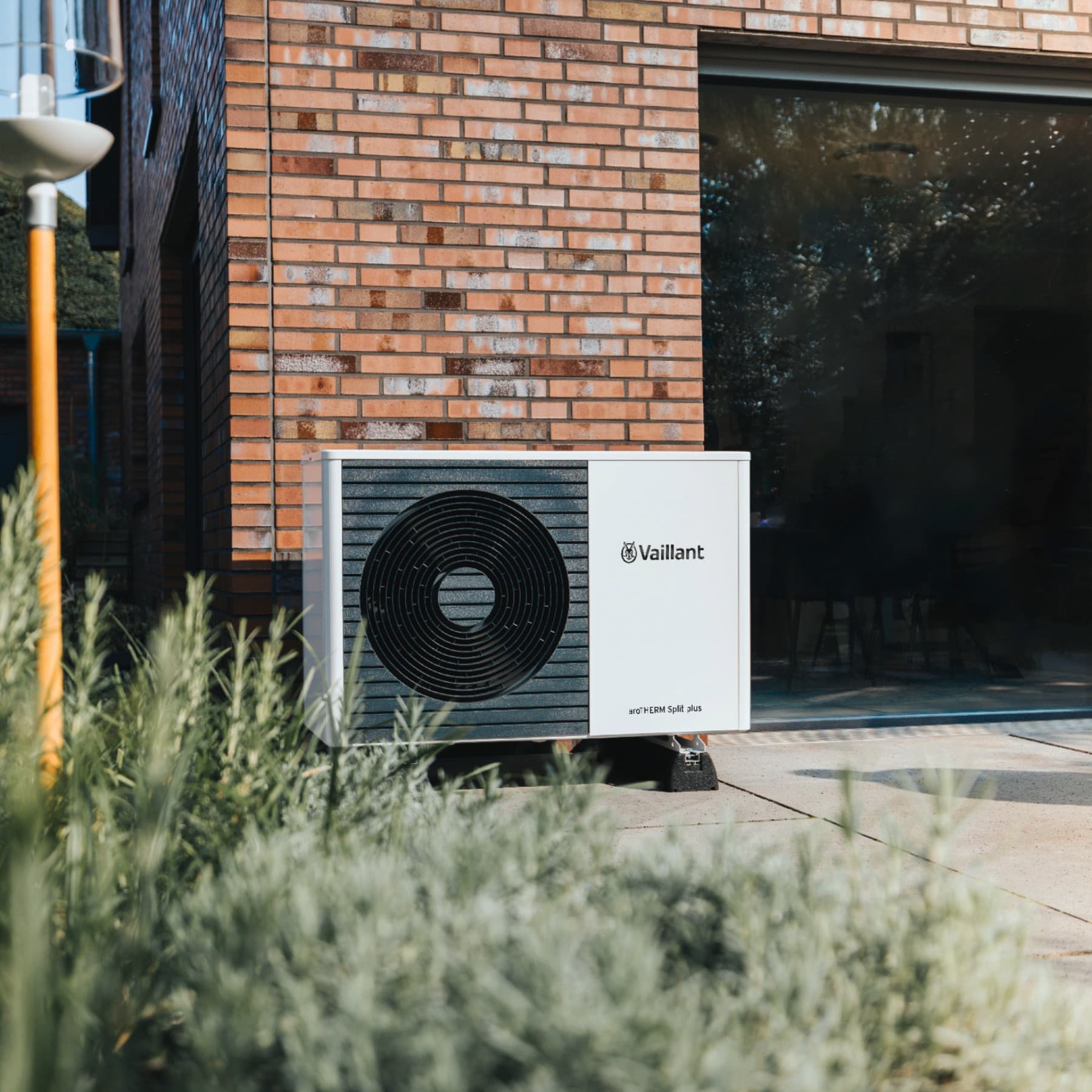 Außeneinheit einer Vaillant Wärmepumpe, die vor einer gemauerten Hauswand steht.