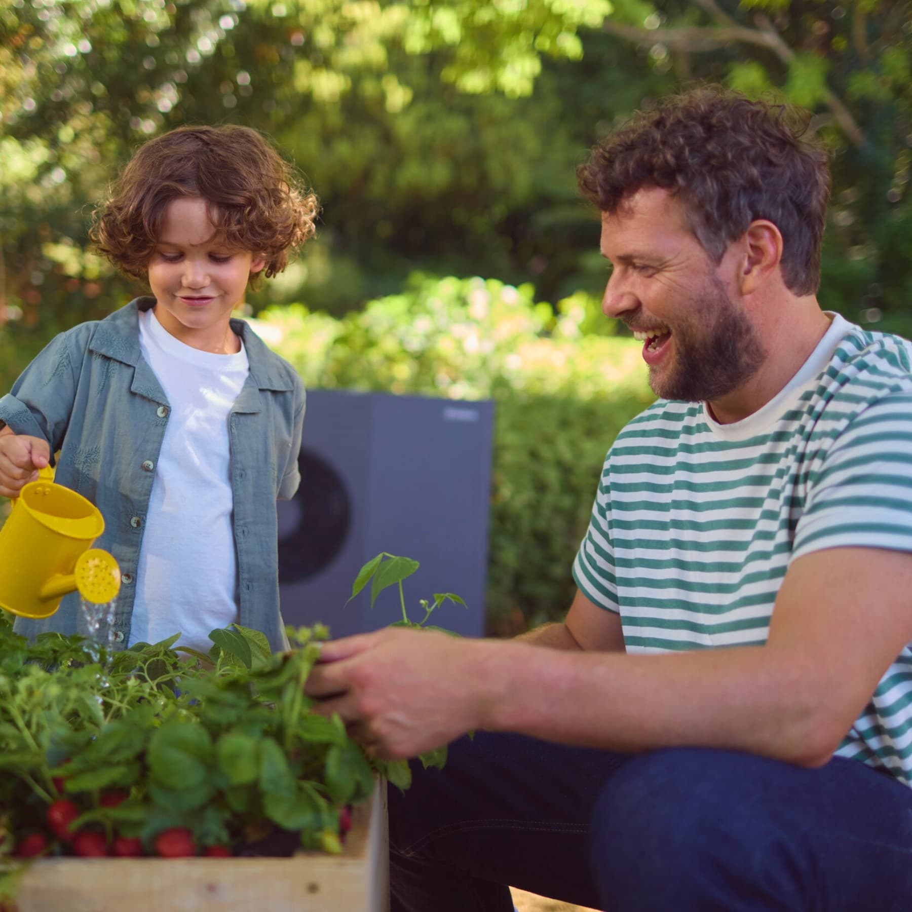 Ein Junge mit seinem Vater vor einer Wärmepumpe