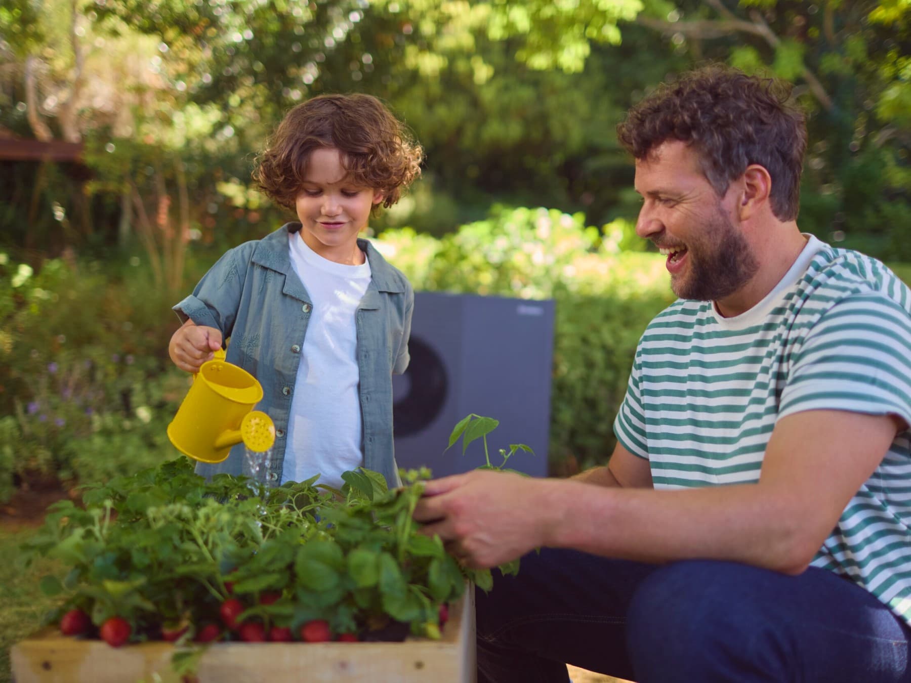 Ein Junge mit seinem Vater vor einer Wärmepumpe