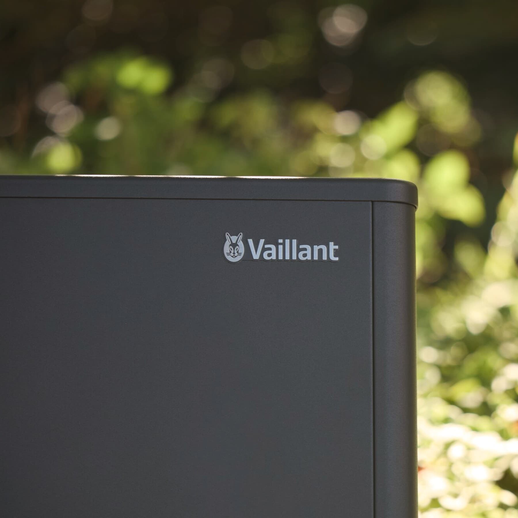 Wärmepumpen Außeneinheit aroTHERM Split, die in einem sommerlichen Garten steht