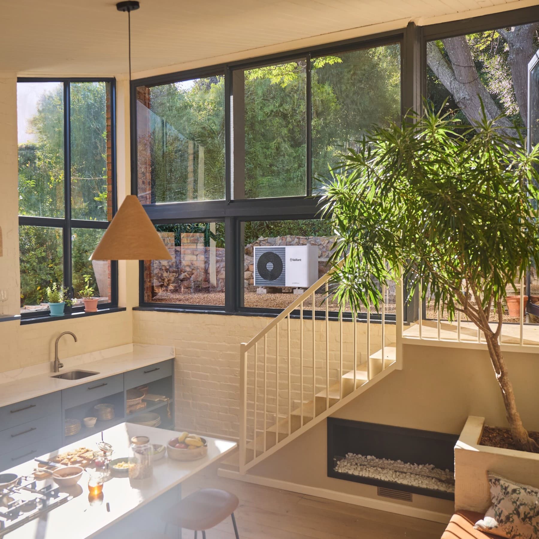 Innenansicht einer Küche, durch das Fenster ist eine Vaillant Wärmepumpe im Garten zu sehen