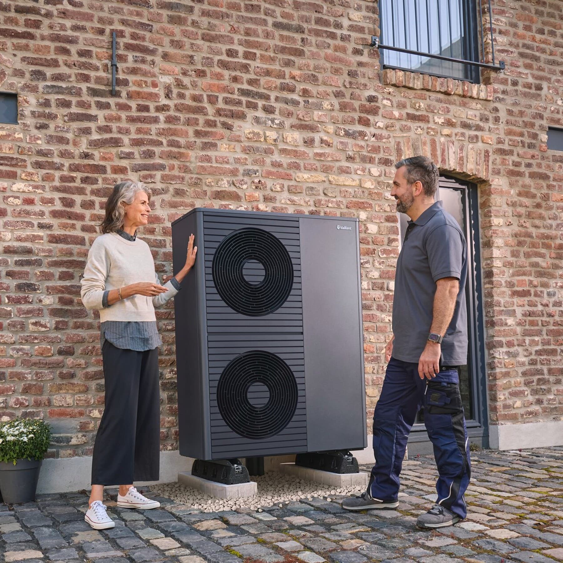 Zwei Personen vor einer schwarzgrauen Vaillant Wärmepumpe