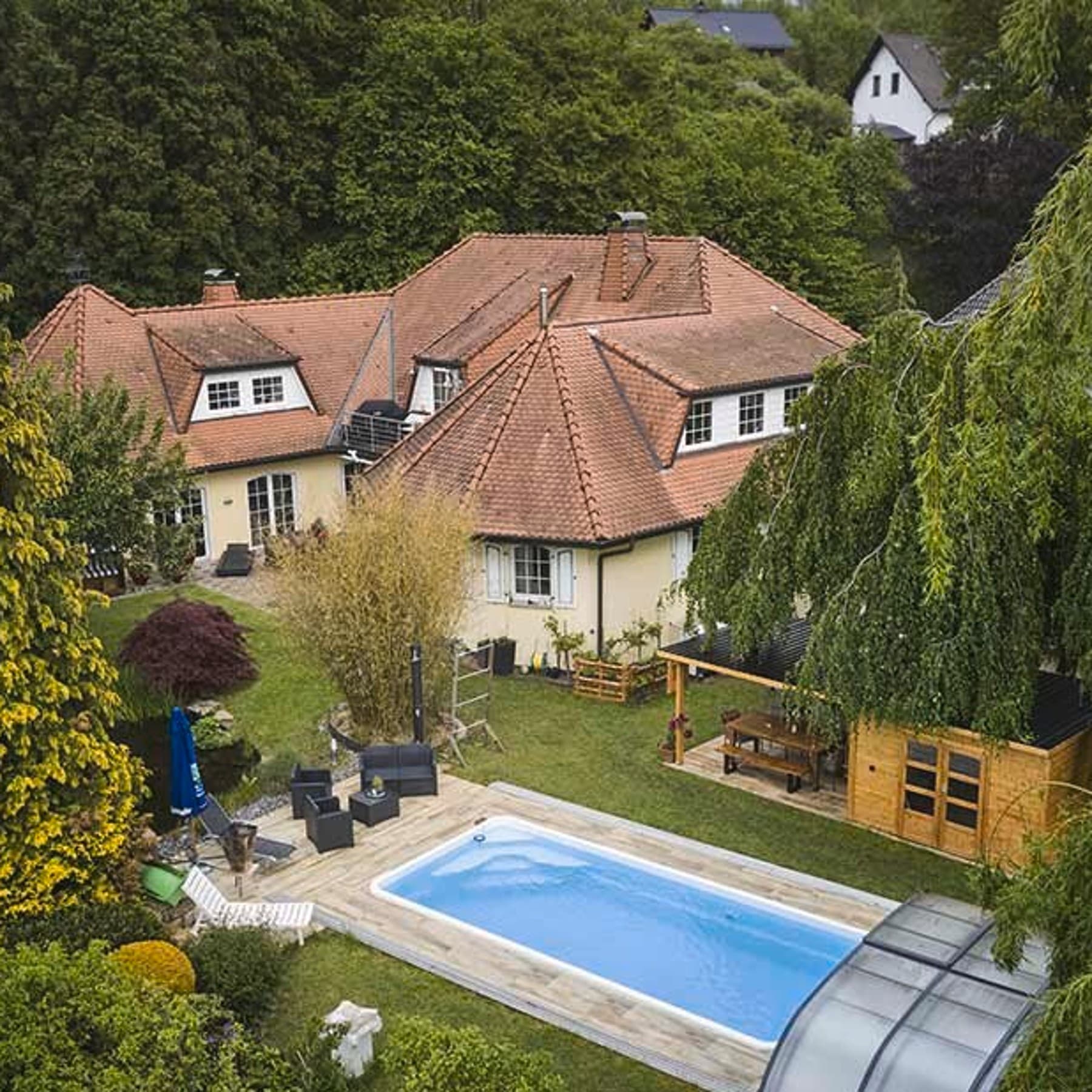 Ansicht des Hauses und des Gartens aus Vogelperspektive, im Vordergrund ein eingelassener Pool