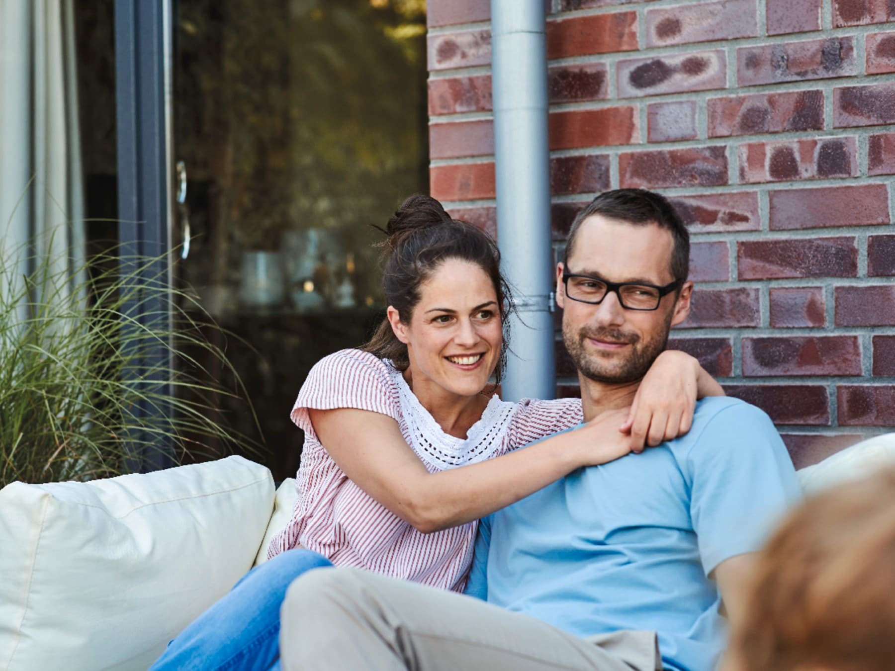 Paar sitzt auf einer Couch auf der Terrasse