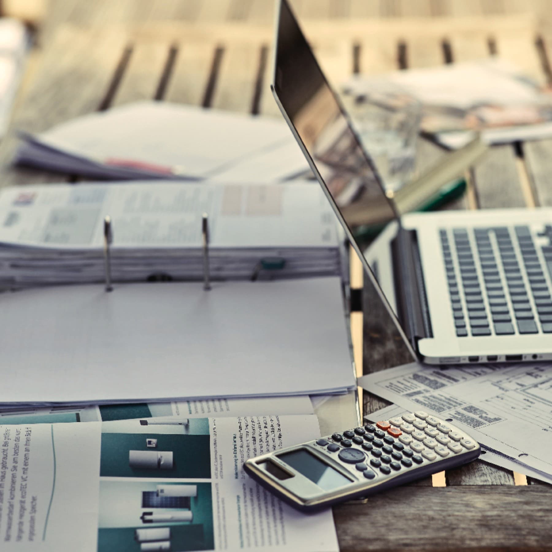 Bild von einem Laptop und einem Ordner auf einem Tisch