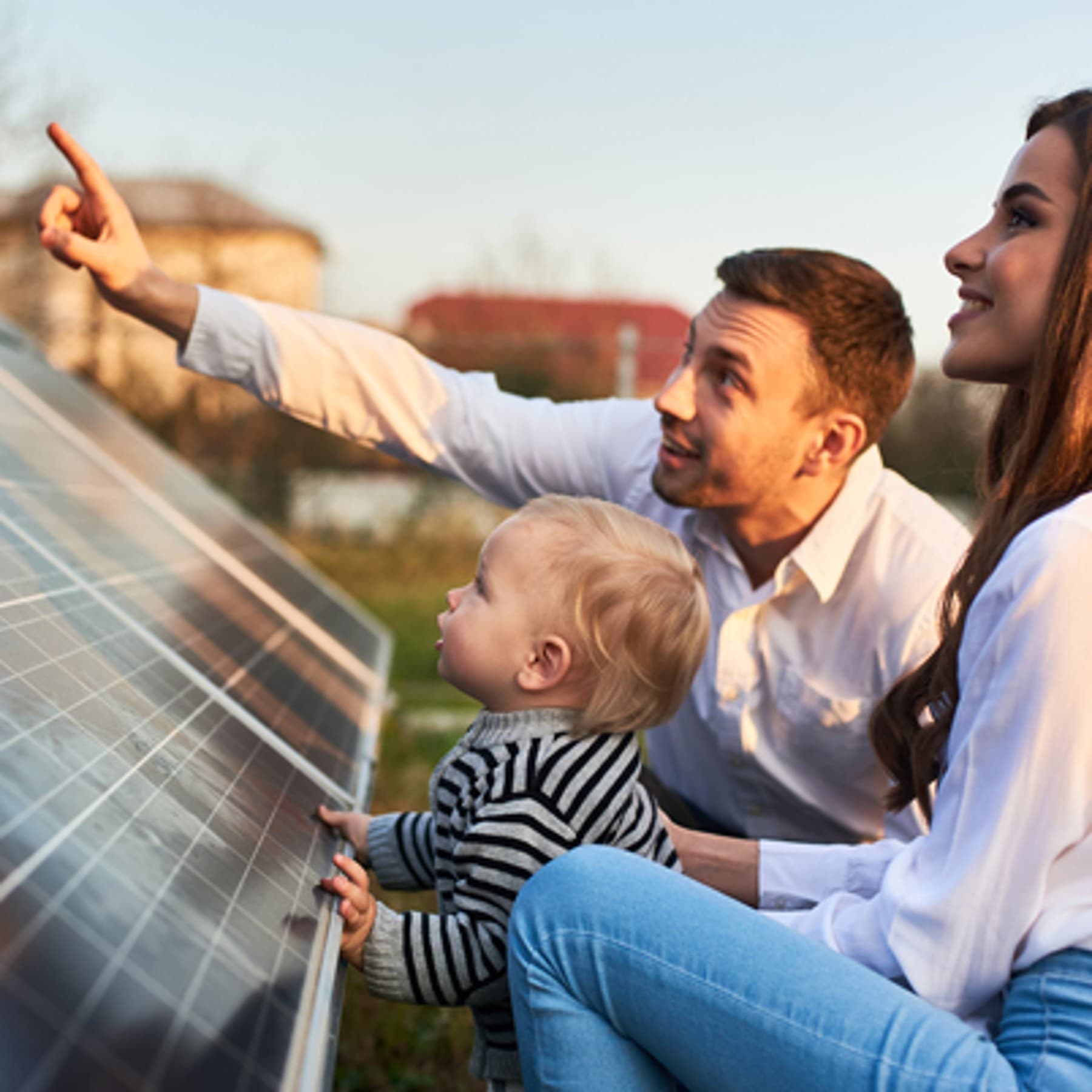 Junge Familie steht vor PV-Modulen