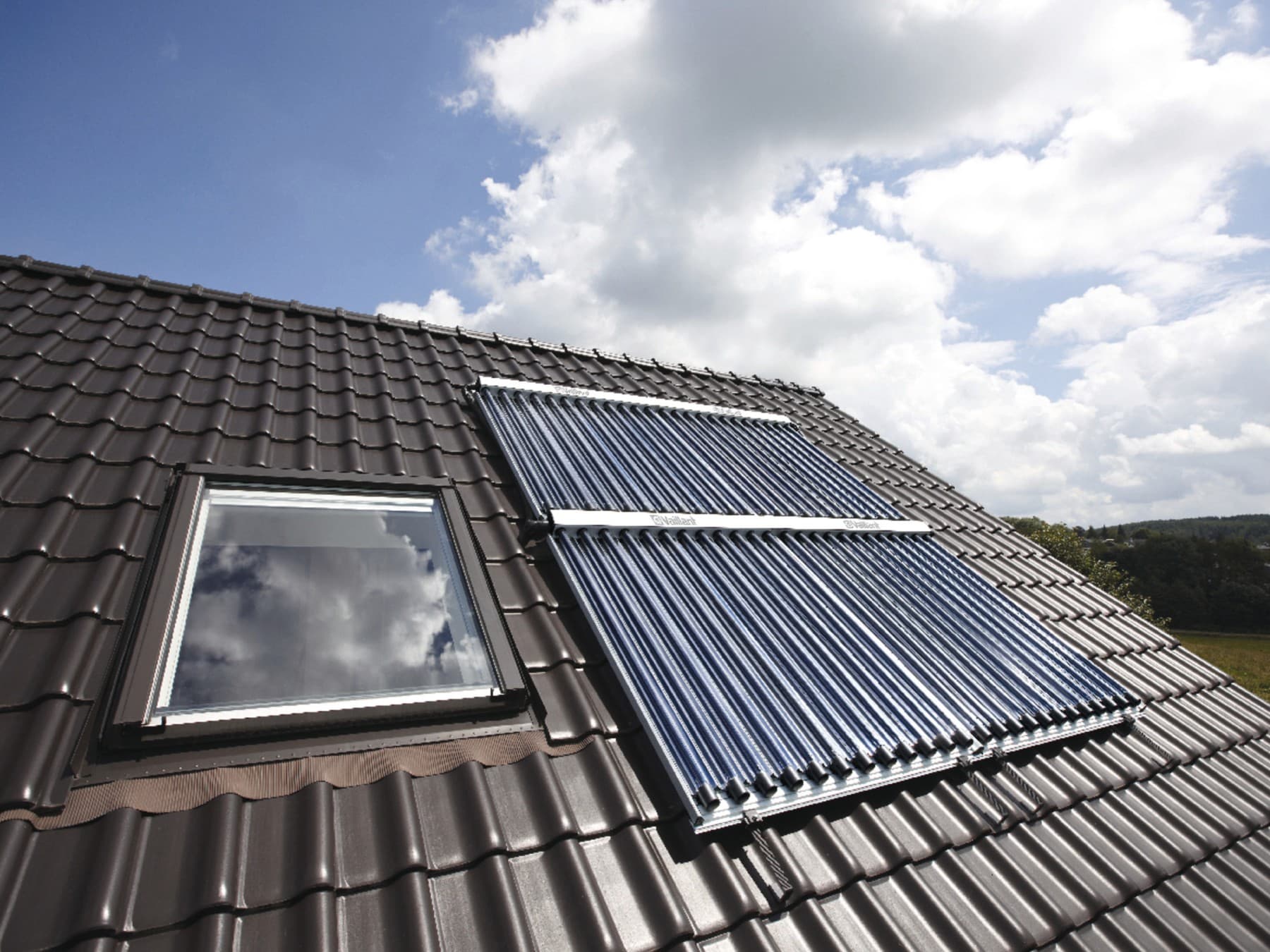 Ein Dach mit schwarzen Dachschindeln und einer Solaranlage auf dem Dach.