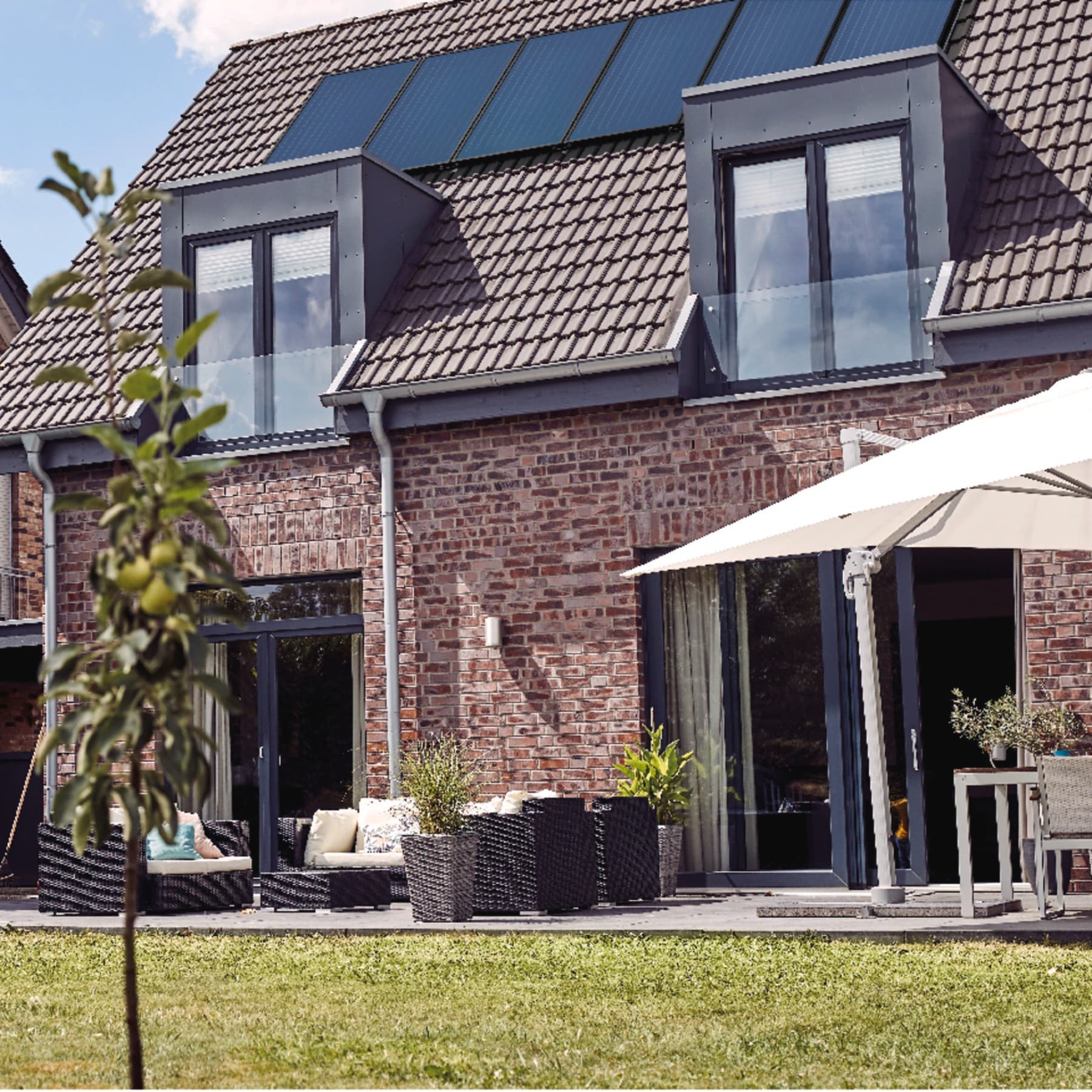 Ein altes Backsteingebäude mit einer Solaranlage auf dem Dach.