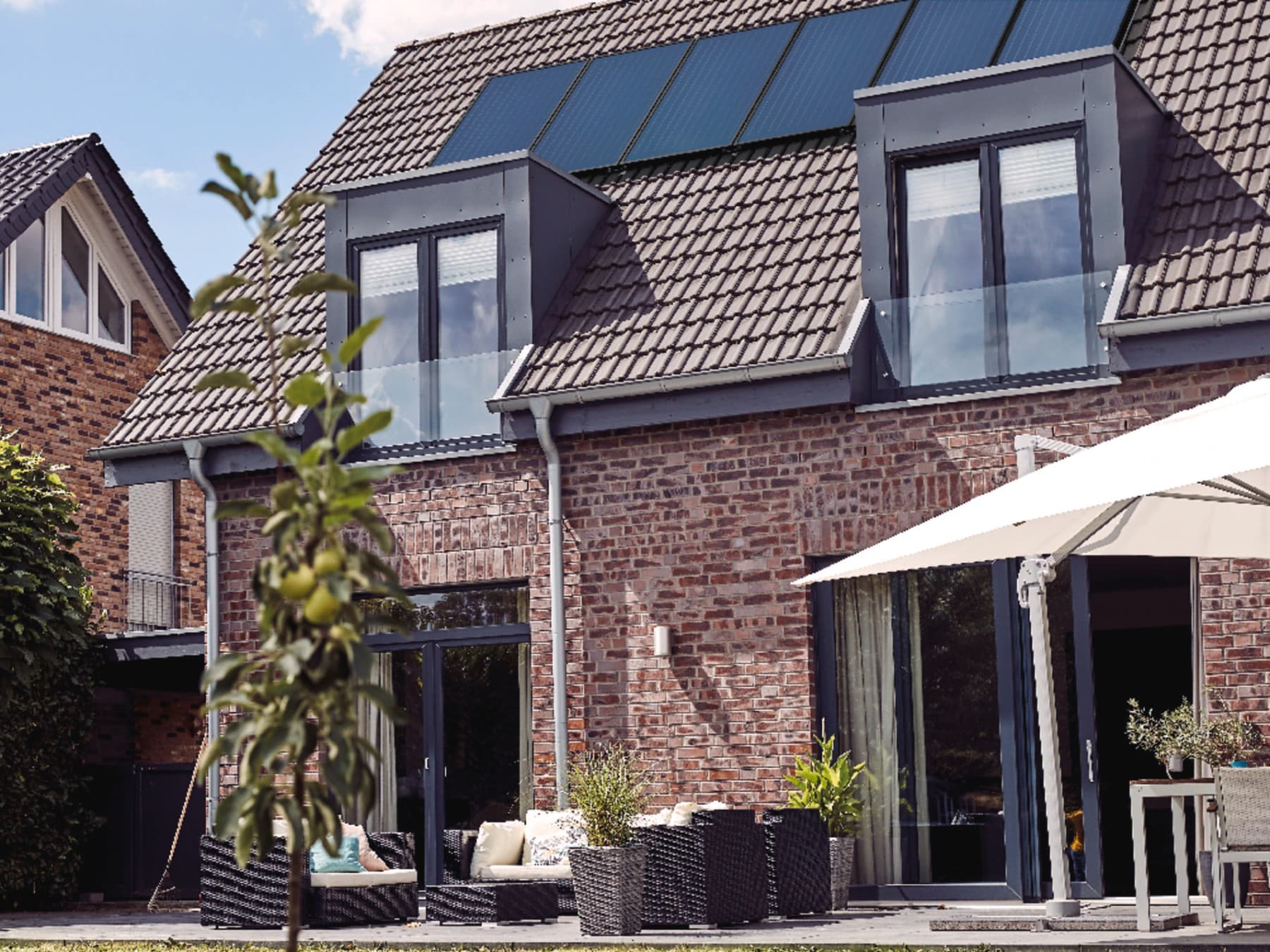 Außenansicht eines Hauses mit Photovoltaik auf dem Dach