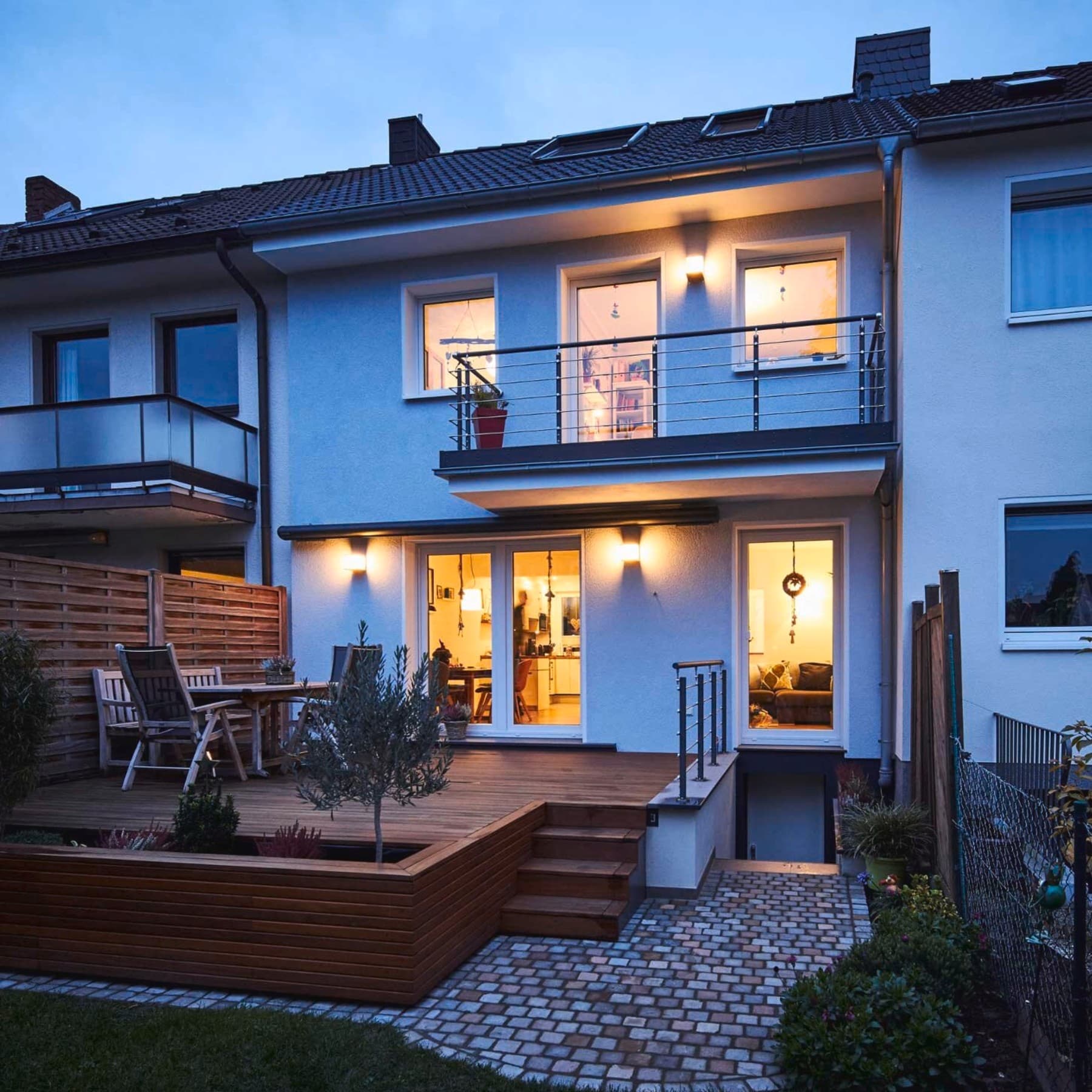 Rückansicht auf das Reihenmittelhaus mit Terrasse, im Haus brennen Lichter