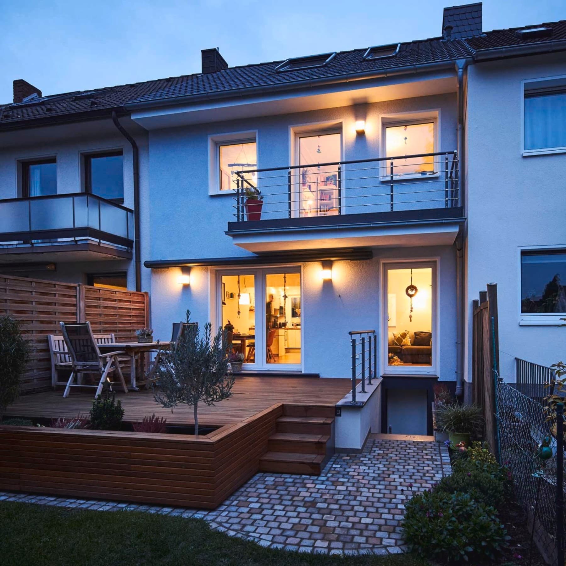 Ansicht des Reihenmittelhauses aus dem Garten bei Dämmerung