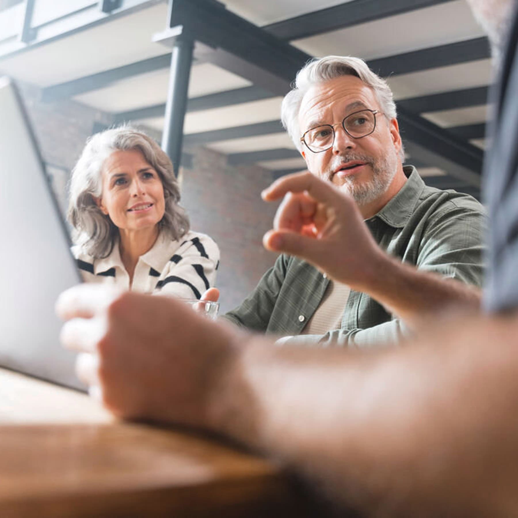 Am Tisch sitzendes Pärchen in einer Beratngssituation