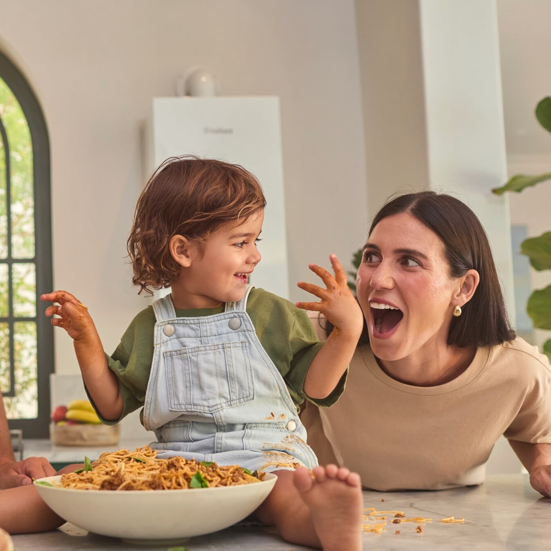Eine Familie ist in der Küche und isst Spaghetti